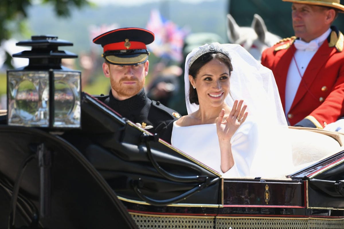 WINDSOR, ENGLAND - MAY 19: (L-R) Prince Harry, Duke of Sussex and Meghan, Duchess of Sussex leave Windsor Castle in the Ascot Landau carriage during a procession after getting married at St Georges Chapel on May 19, 2018 in Windsor, England. Prince Henry Charles Albert David of Wales marries Ms. Meghan Markle in a service at St George's Chapel inside the grounds of Windsor Castle. Among the guests were 2200 members of the public, the royal family and Ms. Markle's Mother Doria Ragland. (Photo by Karwai Tang/WireImage)