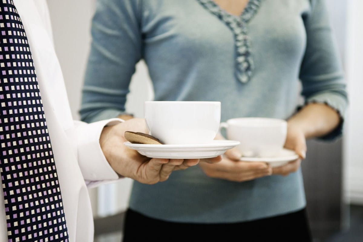 Women drinking coffee together in an office