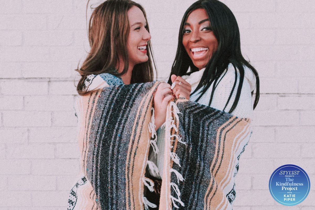 Two women in blankets smiling