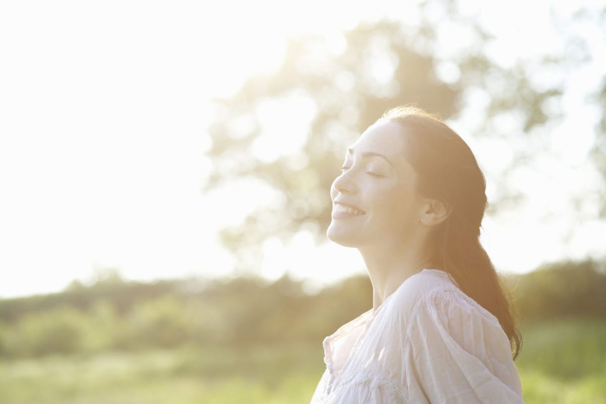 Woman smiling in park in sunlight