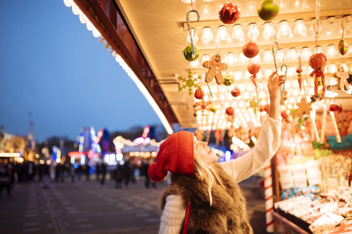 Young woman choosing baubles at xmas festival in Hyde Park, London, UK