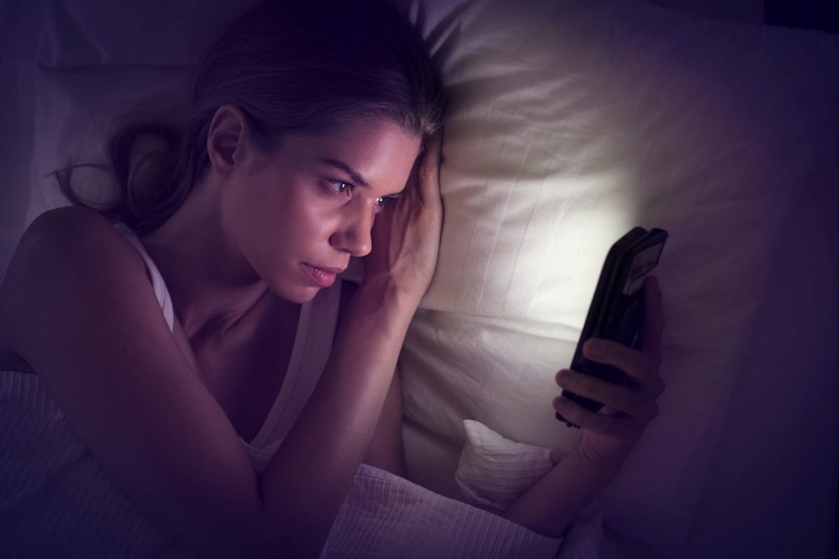 A woman on social media at bed