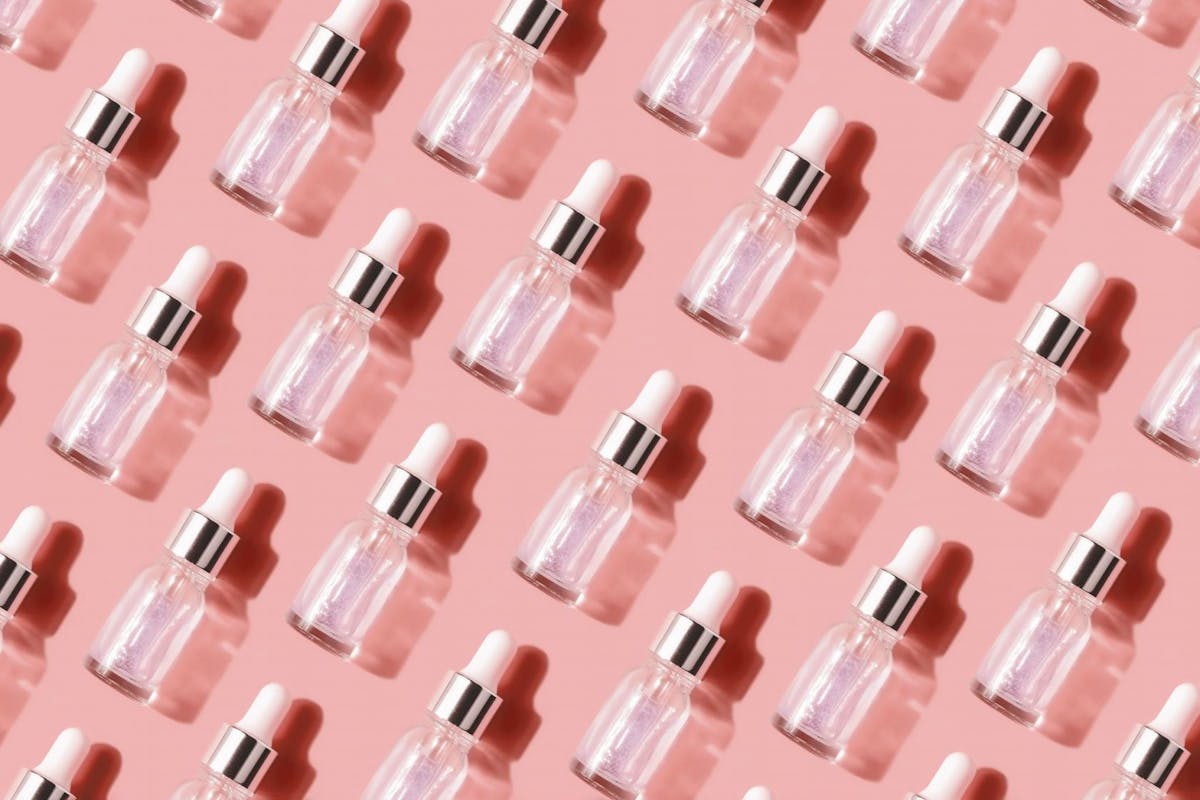 A handful of clear skincare serum bottles lined up neatly