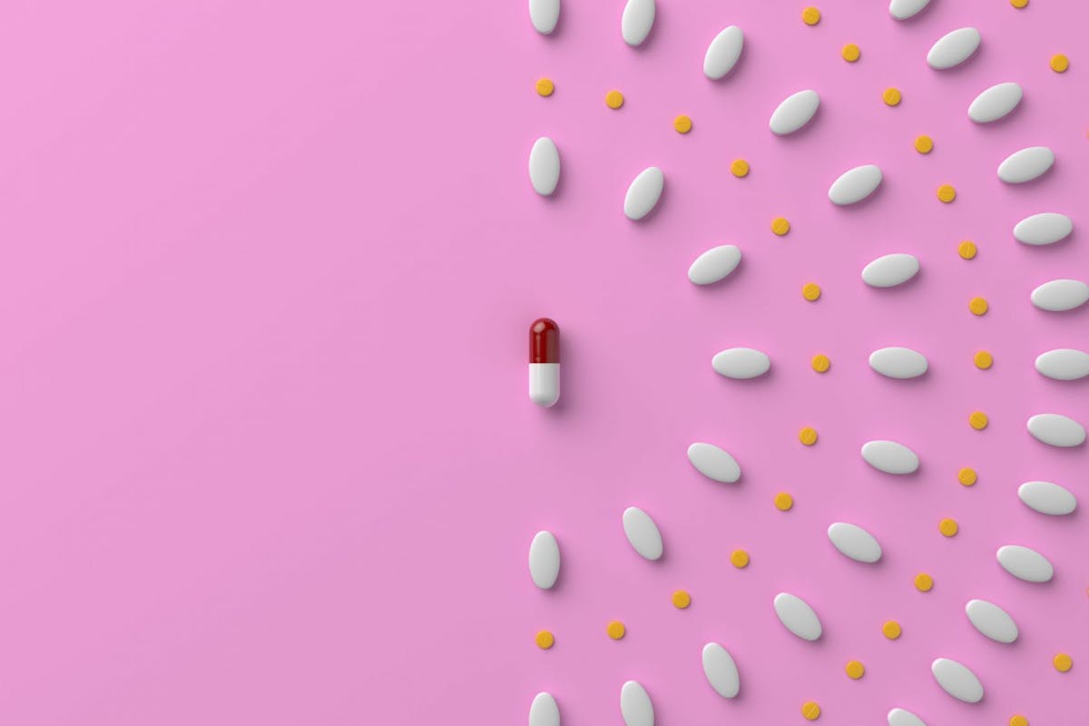 Image of pill capsules on a pink background