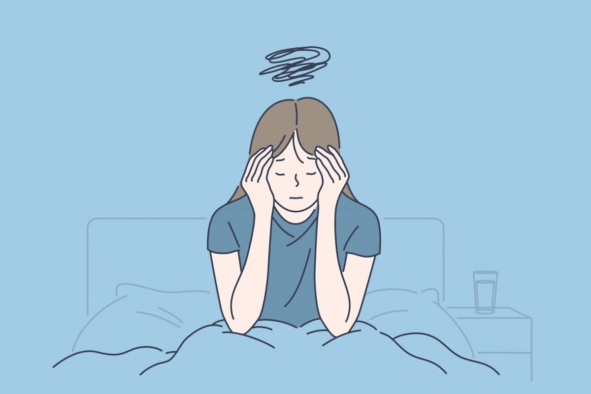 A woman in bed feeling overwhelmed