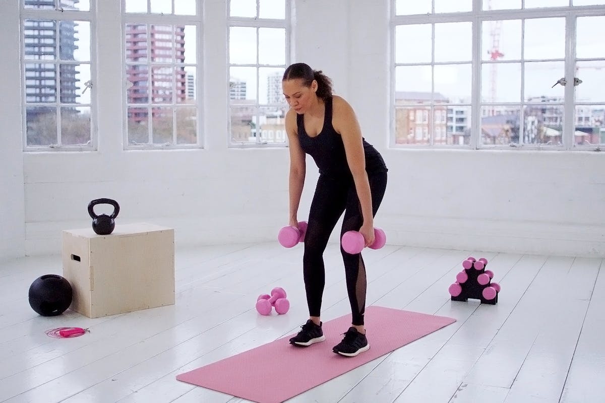 Woman completing an upper body workout with dumbbells