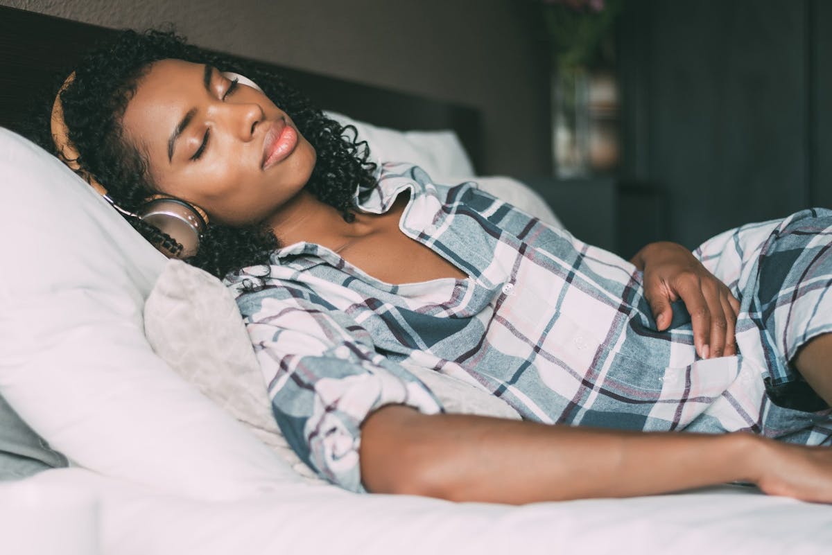 A woman asleep listening to a sleep story