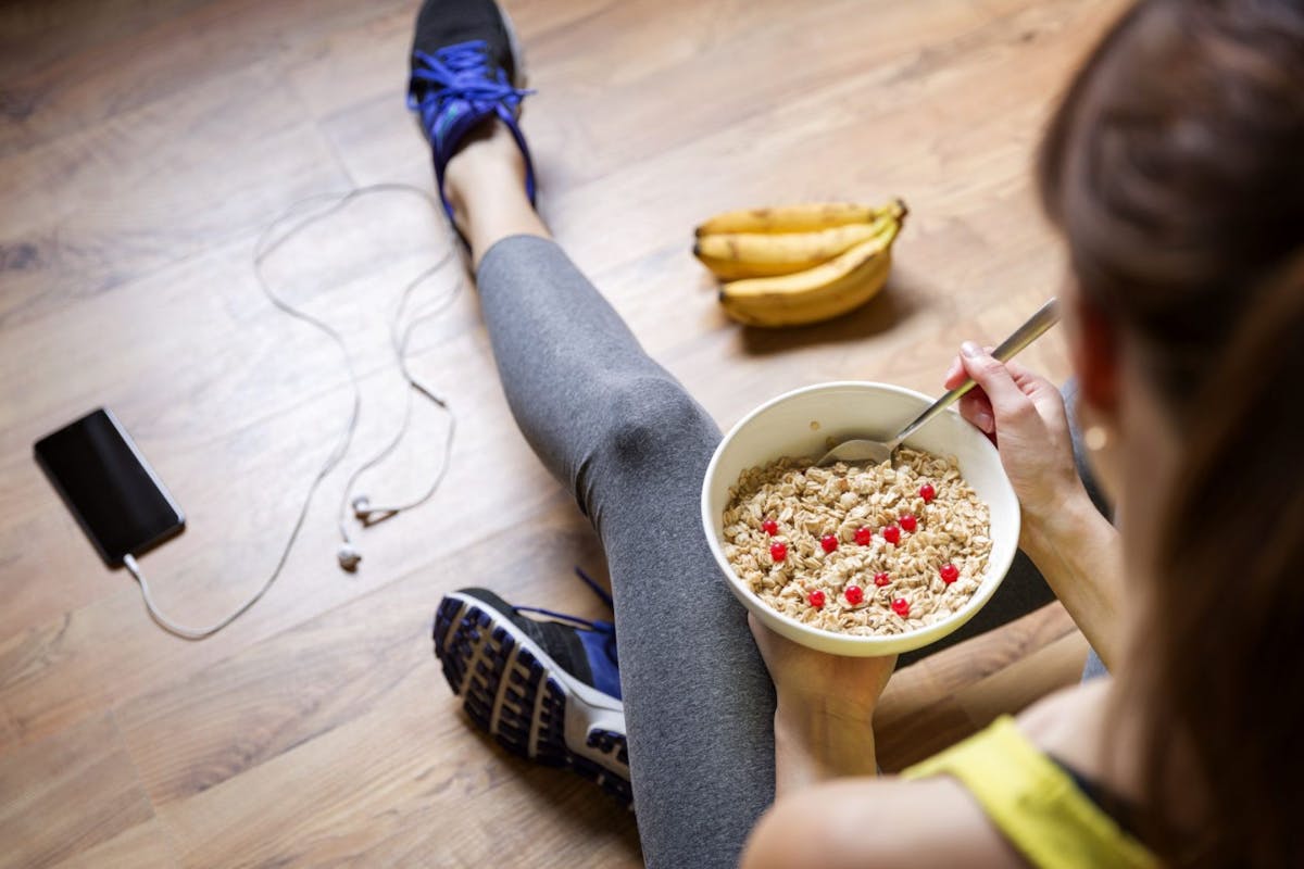 A woman eating cereal and a banana before working out