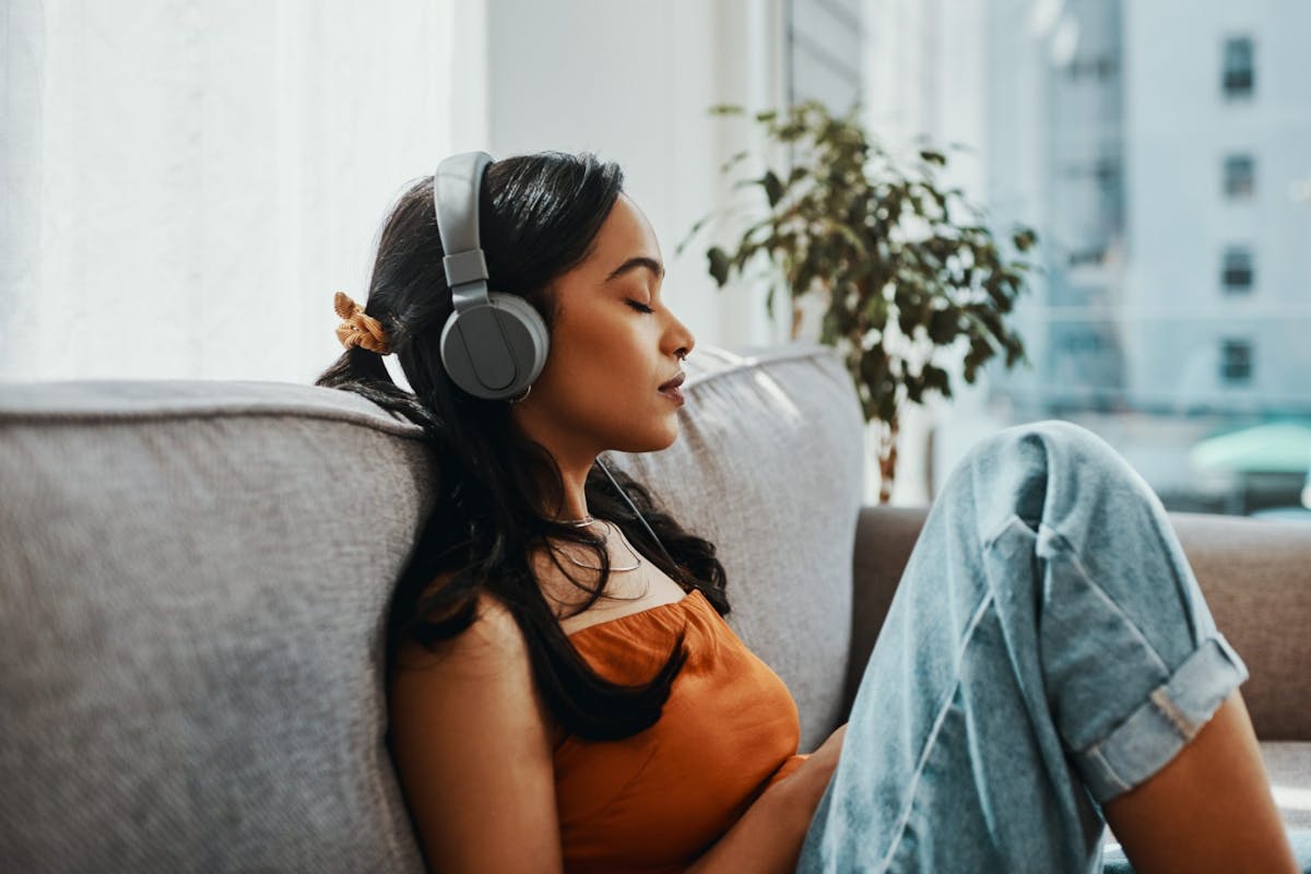 A woman listening to headphones with her eyes closed