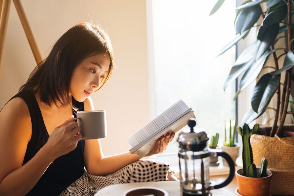 woman reading best quotes for the new year with a cup of coffee