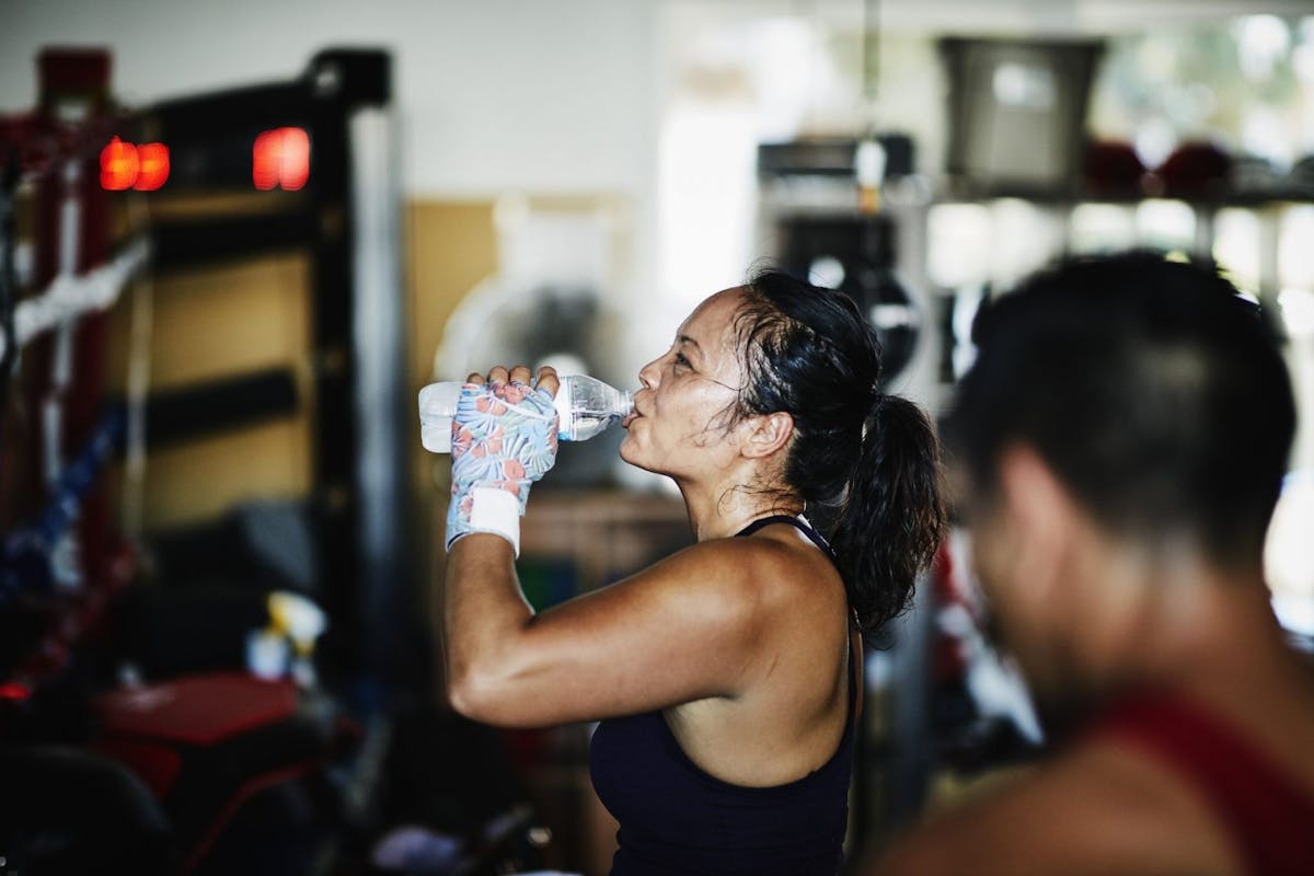 Woman drinking water at the gym