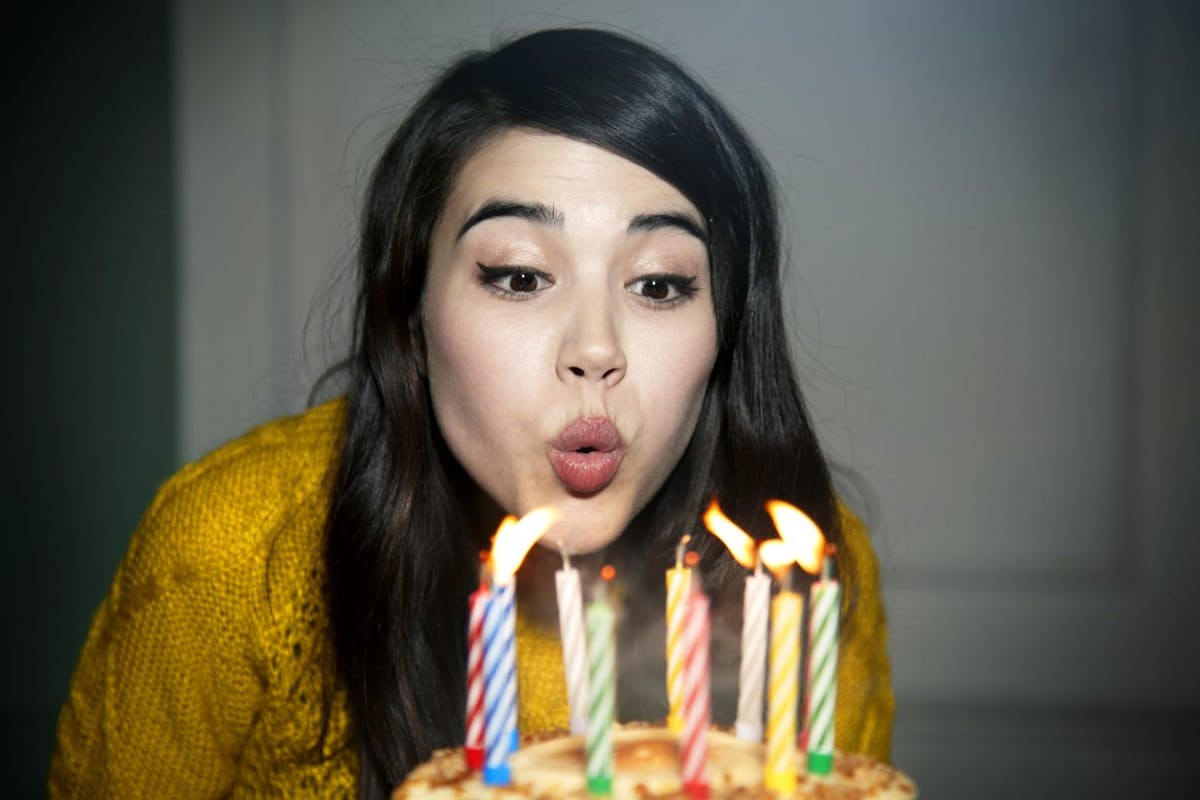 Woman blowing birthday cake