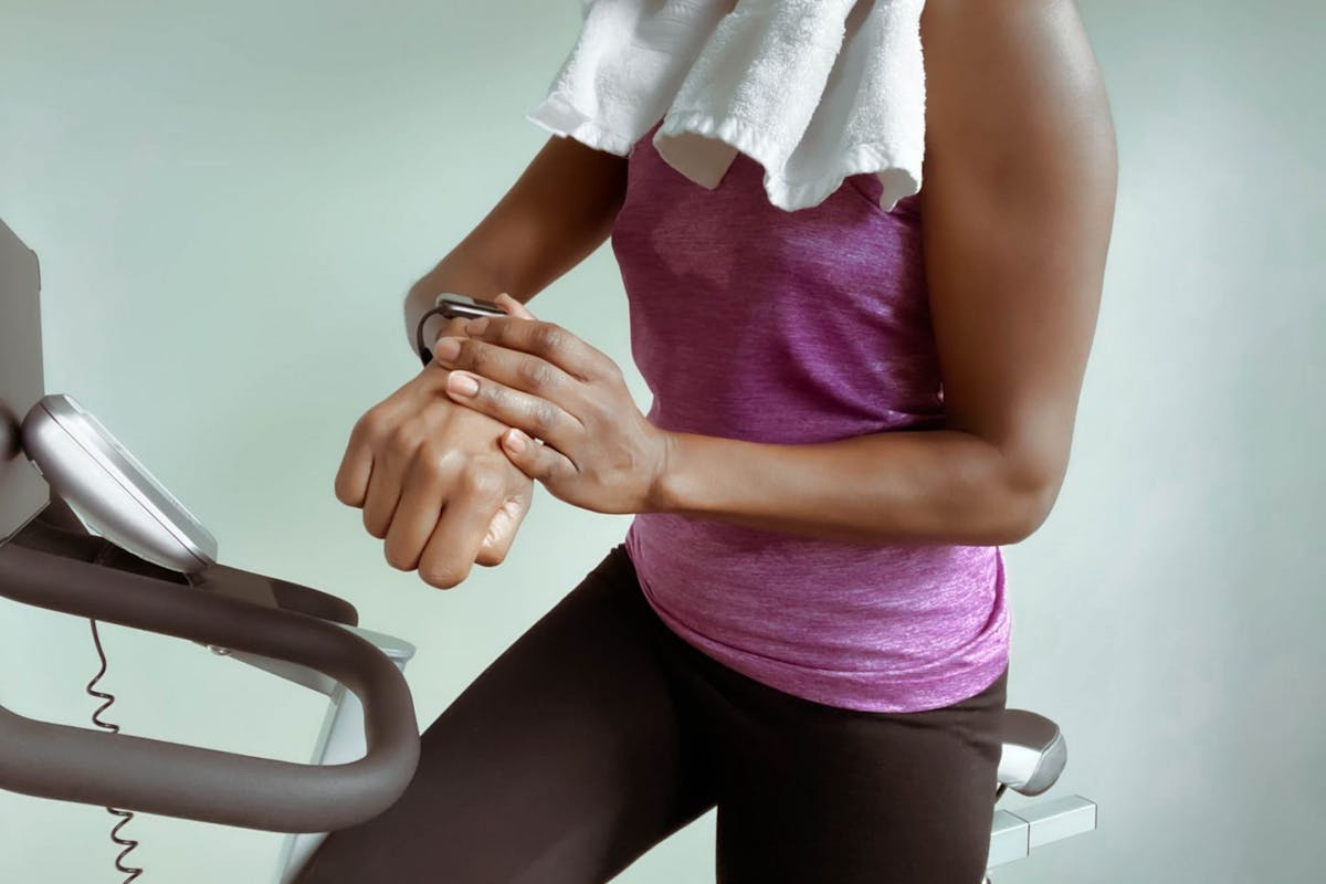 Woman on a treadmill exercise snacking looking at her watch