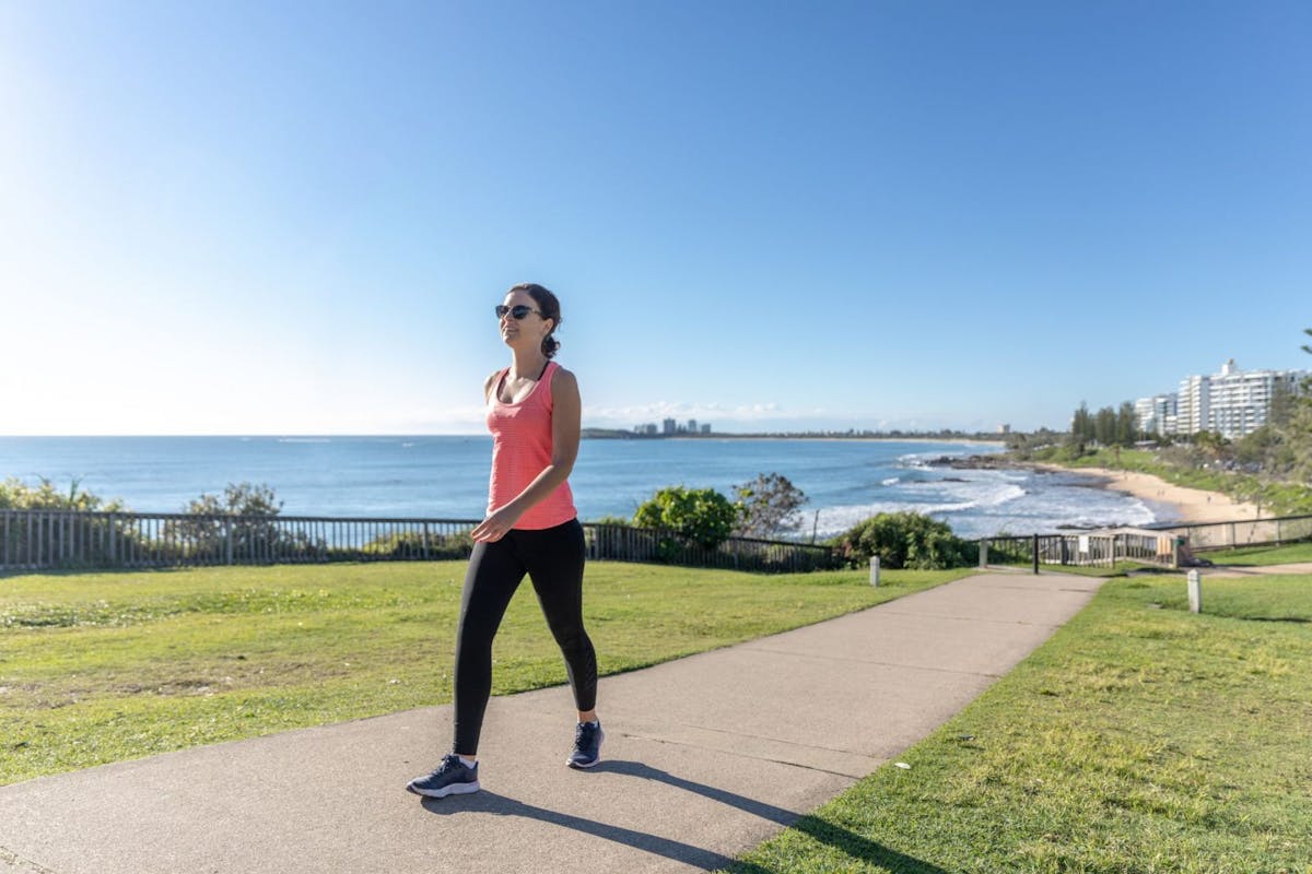 Woman walking by the beach: Is a daily walk enough to keep you fit?