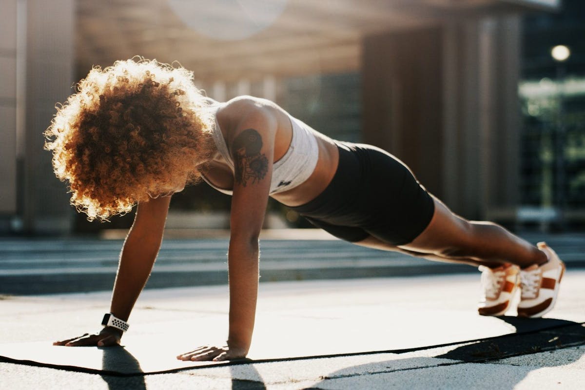 A woman in a high plank position doing cardio workout.