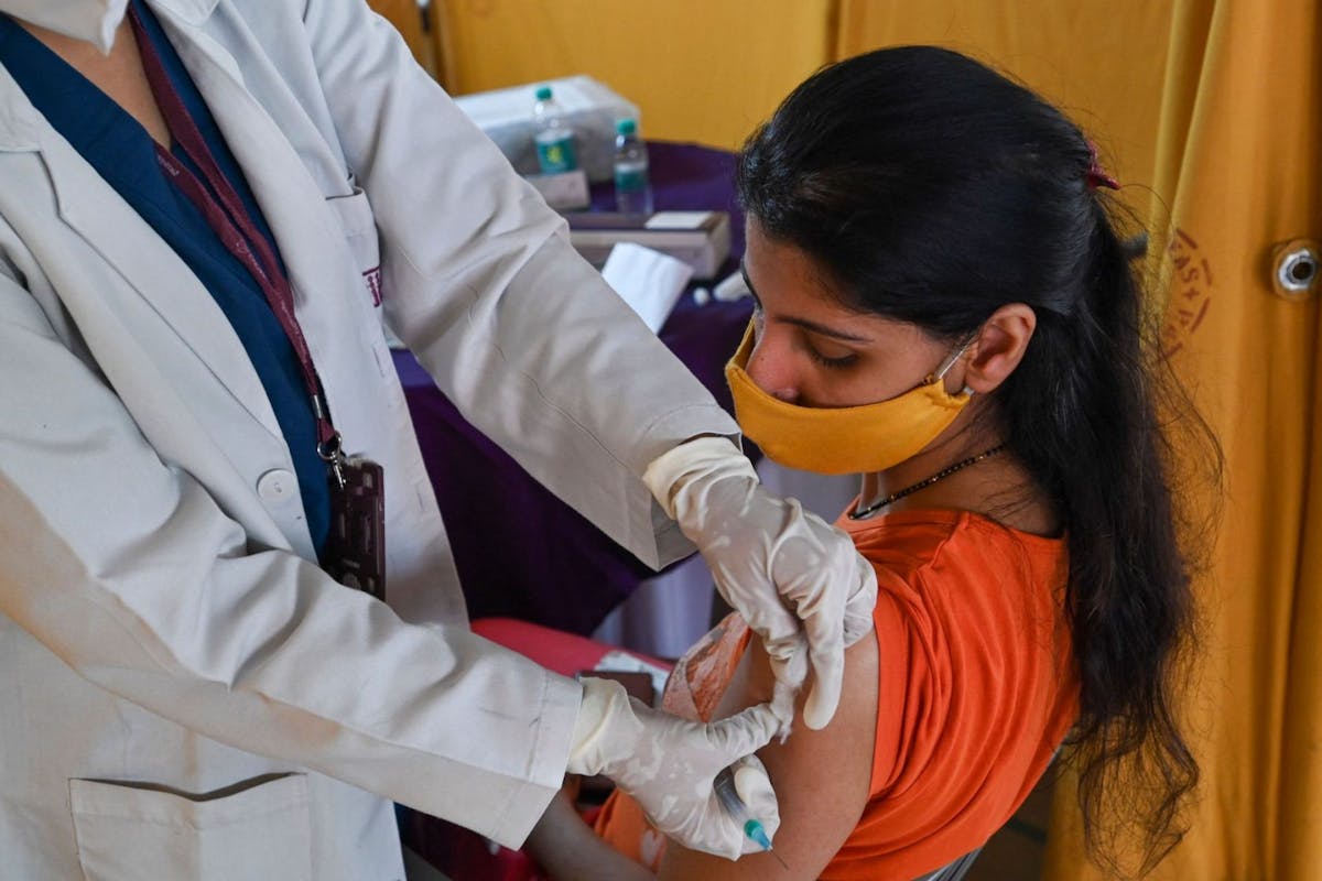 A health worker inoculates a woman with a dose of the Covishield Covid-19 coronavirus vaccine at a vaccination centre in New Delhi on May 6, 2021.