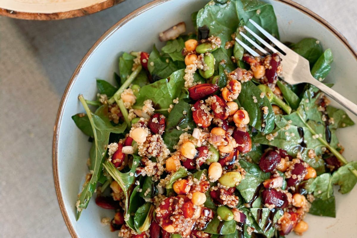 Power protein salad of chickpeas, kidney beans, quinoa and spinach on a plate.