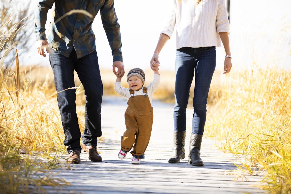 boy holding hands with two parents