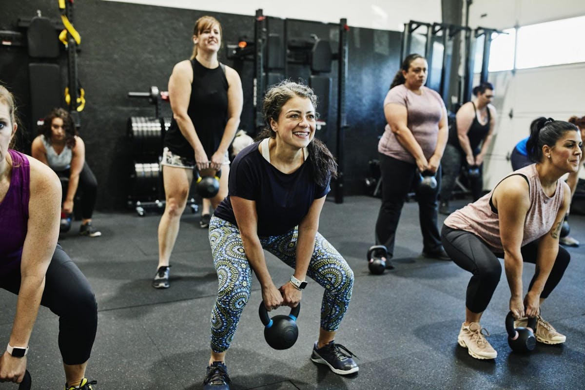 Women doing kettlebell squats in a workout class