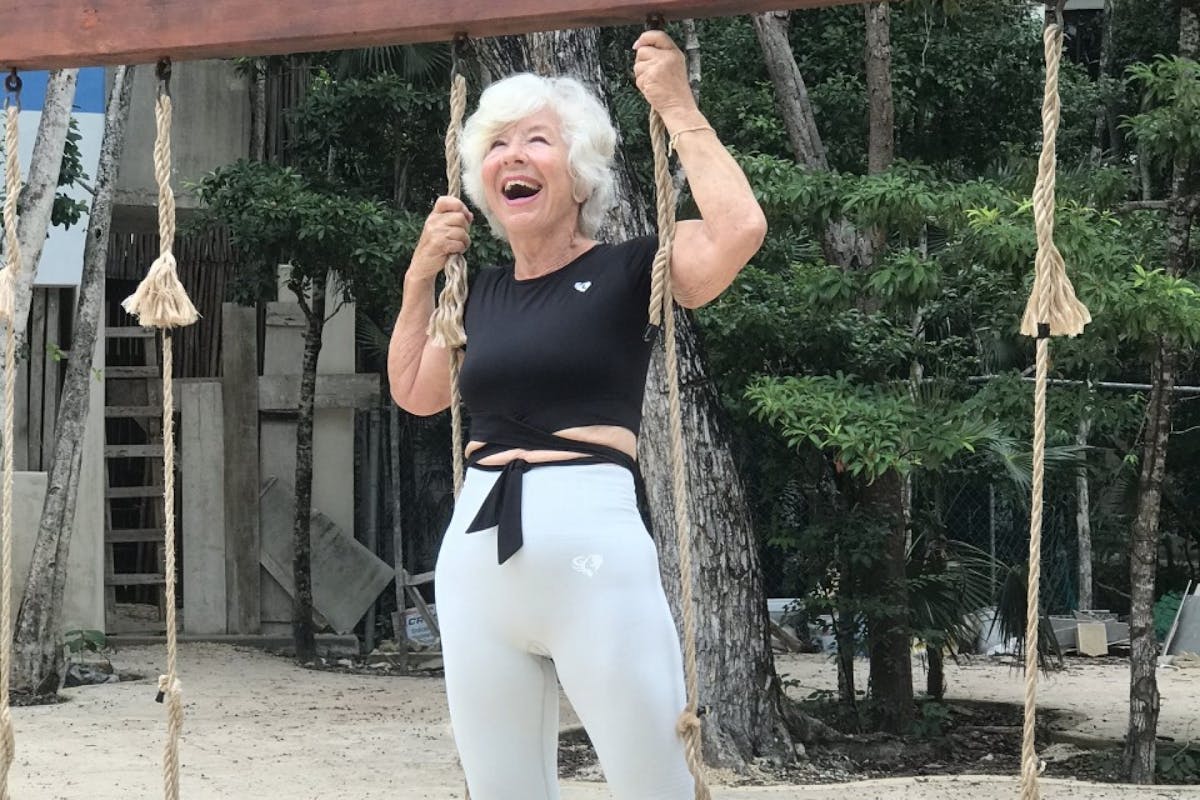 Joan McDonald standing on a swing set in activewear.