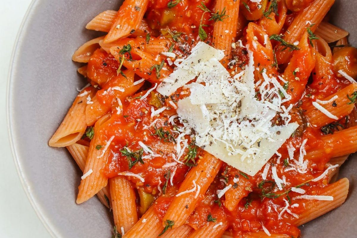 A bowl of pasta with tomato sauce and cheese