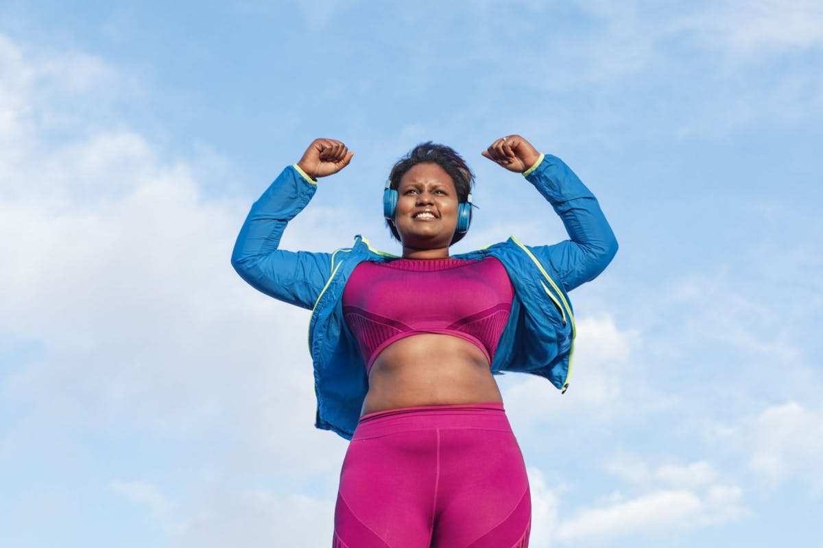 Woman celebrating her workout against blue sky