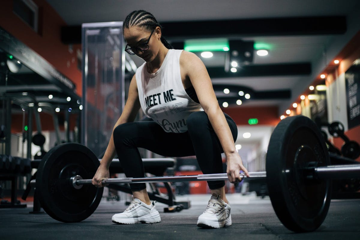 A woman doing a deadlift with a barbell in the gym