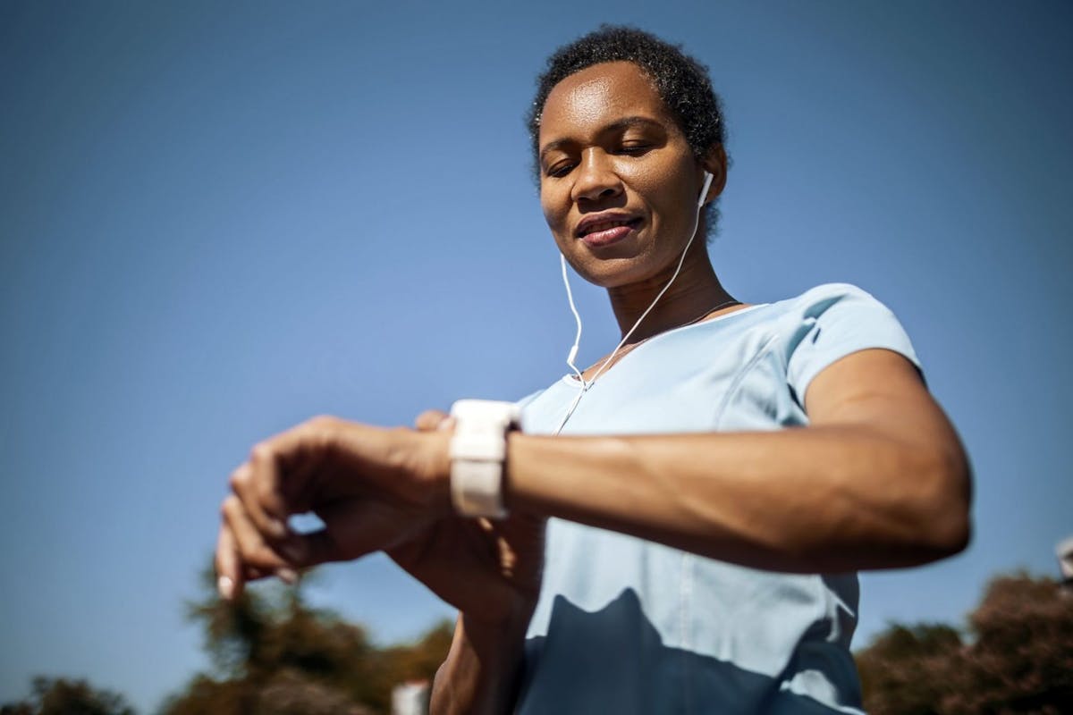 Woman looking at smart watch on a run