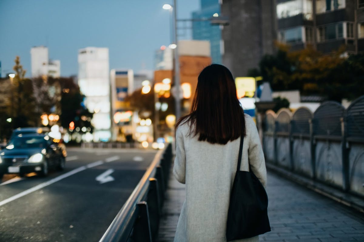 A woman walking on the street at dusk