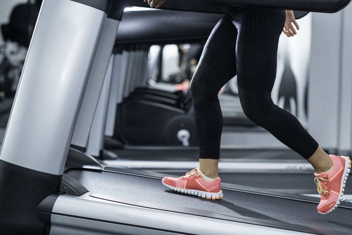 images of woman wearing black leggings and pink trainers walking on a treadmill