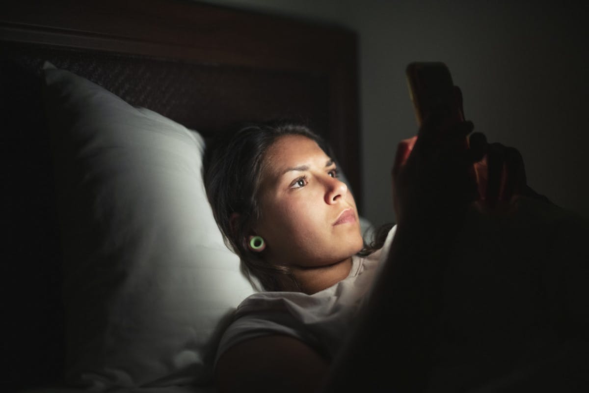 A woman on her phone in bed