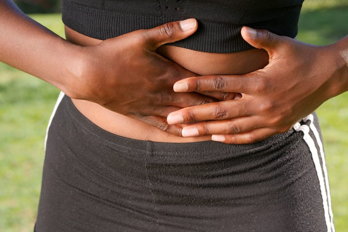 A woman gripping her stomach in activewear