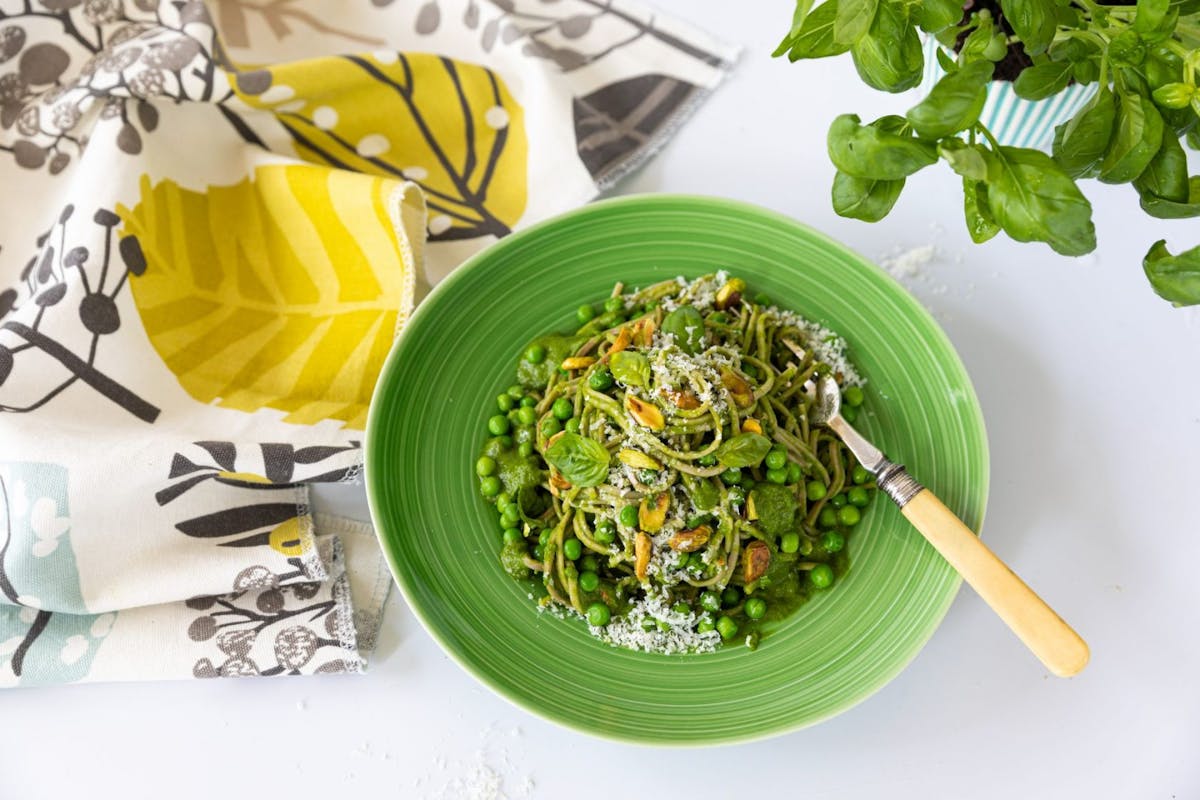 A bowl of buckwheat noodles with creamy pea and kale pesto
