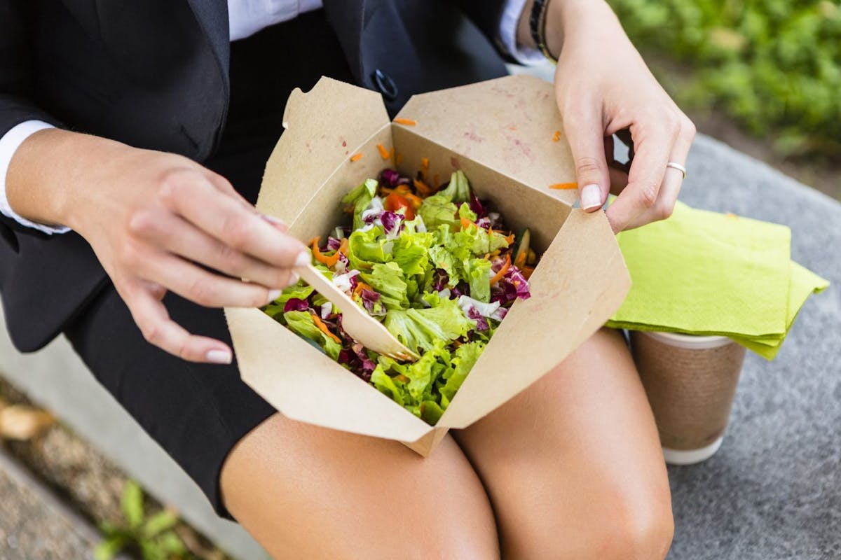 Woman eating salad at work