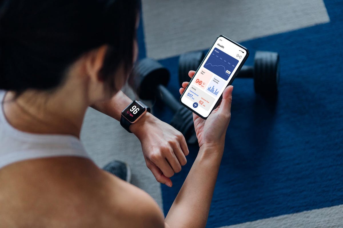 A woman tracking her fitness watch while on her yoga mat