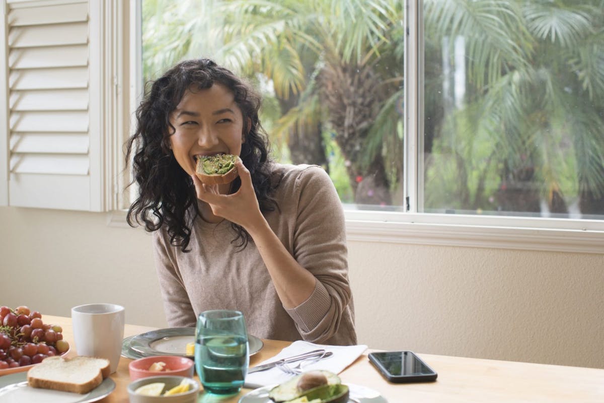 A woman eating avocado on toast