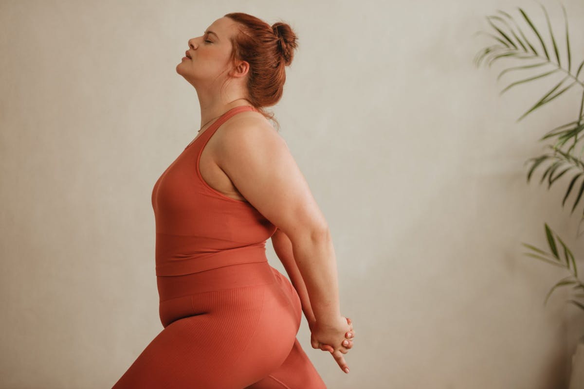 A woman in a yoga pose during a hot yoga class