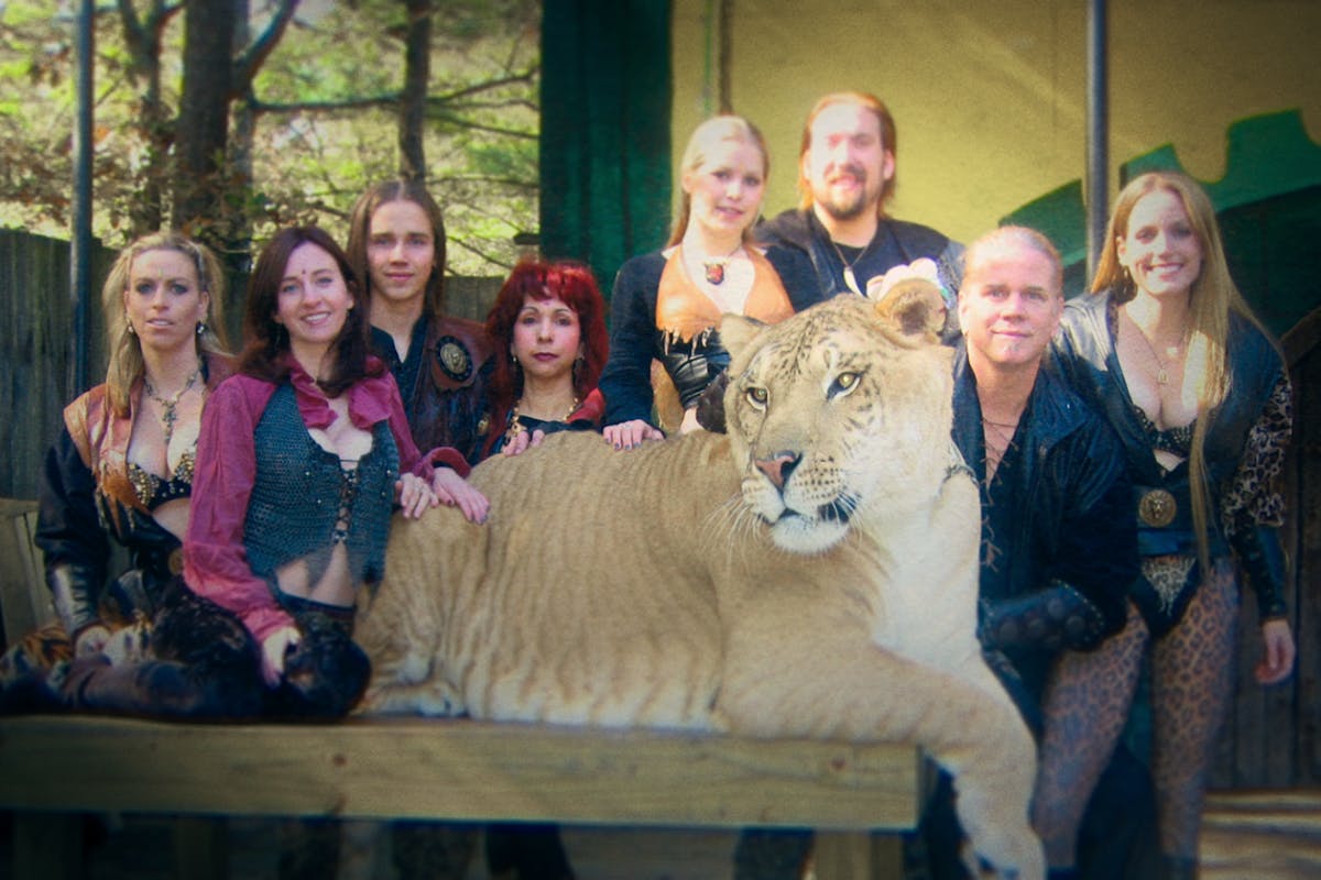 A screenshot from Tiger King: The Doc Antle Story which shows Doc Antle with a lion