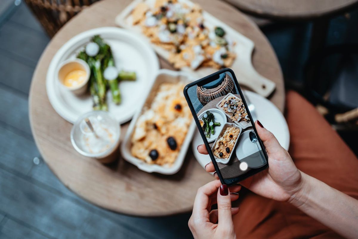 A woman taking a photo of her food on her phone