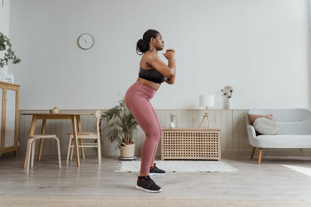 A woman doing squats during a home HIIT workouts