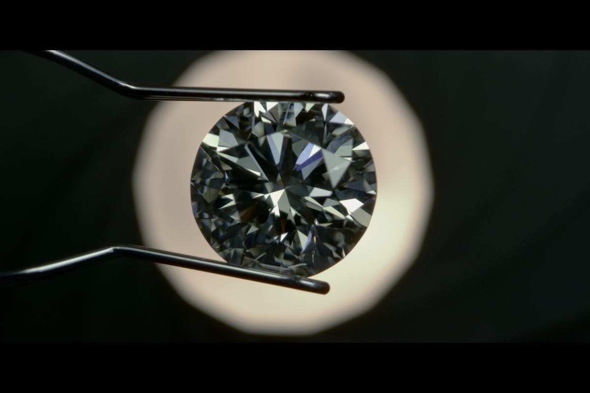 netflix's the tinder swindler production still of diamond under magnifying glass