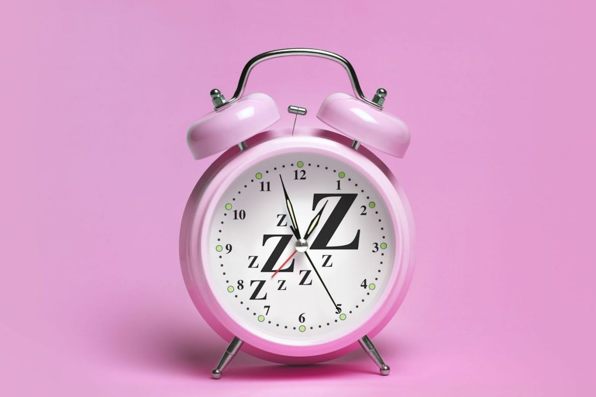 A clock against a pink background with sleep sound written on it
