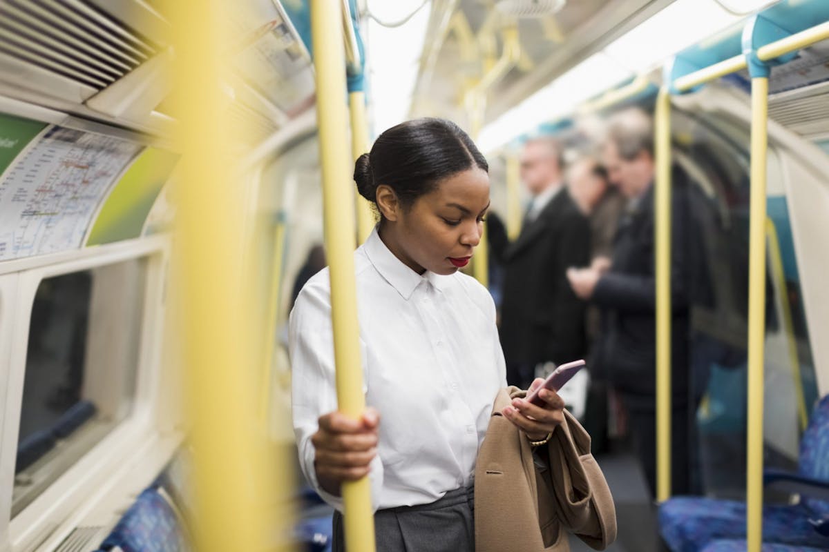 A woman on her phone on the tube