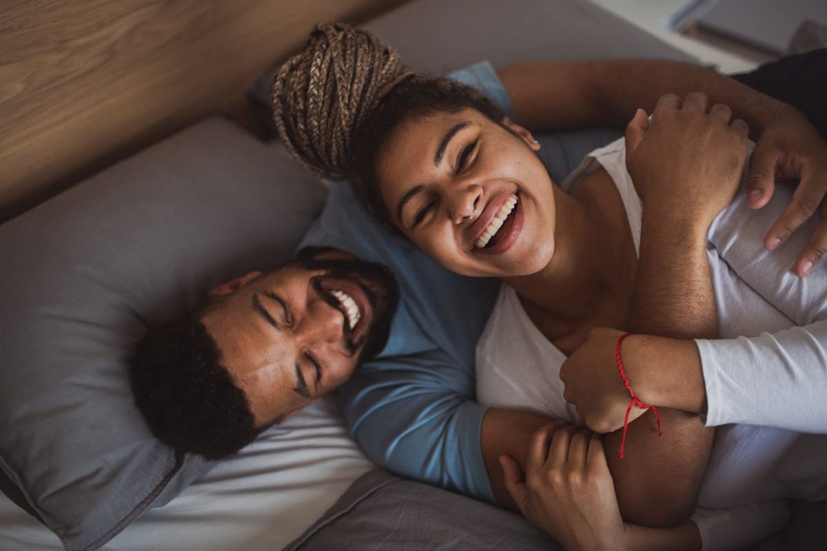 Young couple in bed laughing