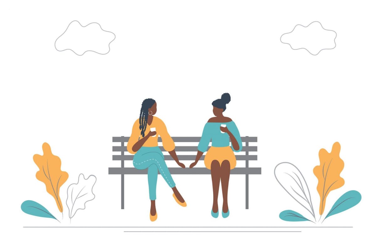Young black women drink coffee on a bench in a park