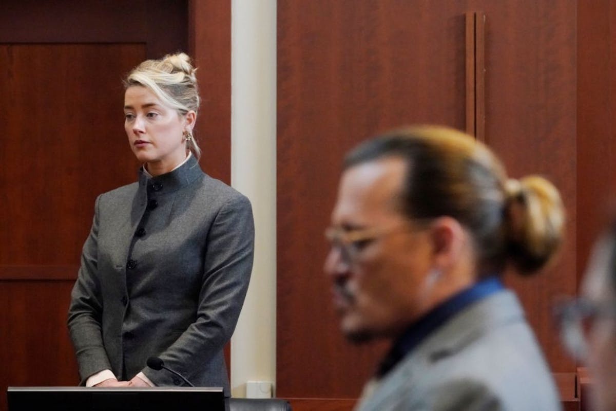 Actors Amber Heard and Johnny Depp watch as the jury leave the courtroom for a lunch break at the Fairfax County Circuit Courthouse in Fairfax, Virginia