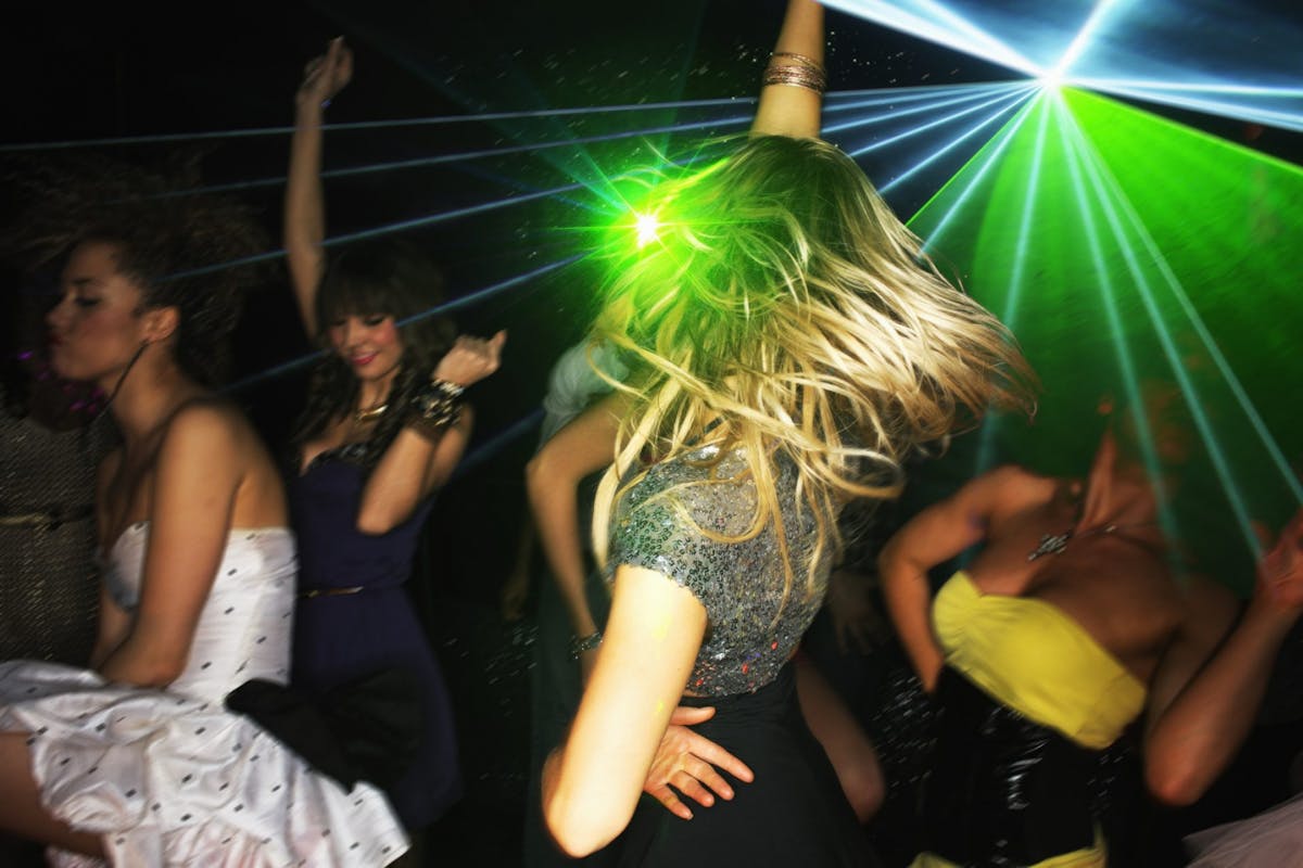 Women living their best lives, dancing in a nightclub