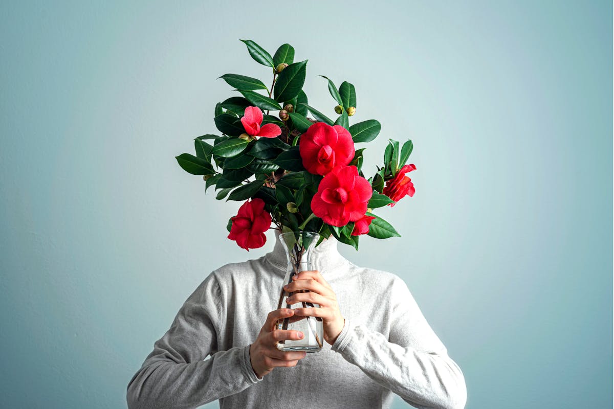 A woman holding flowers over her face