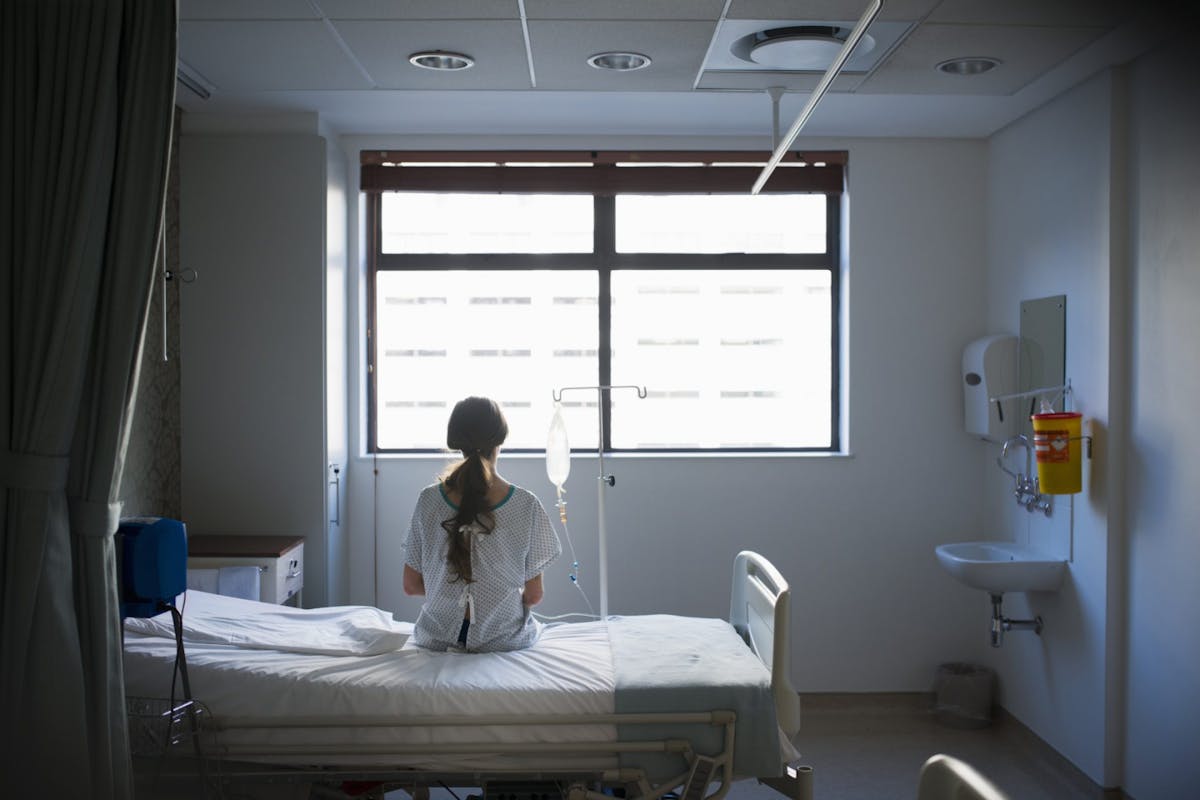 A woman sat on a hospital bed