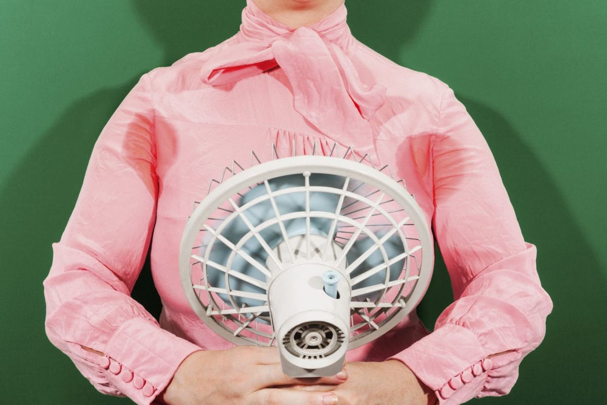 Woman using a fan to stop sweating
